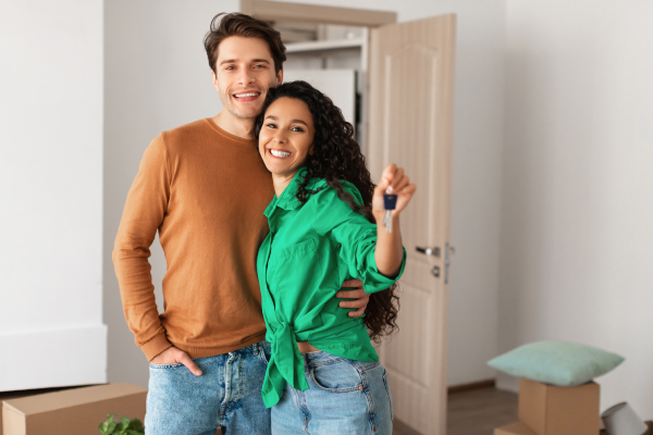 dos jóvenes con la llave de su nuevo hogar
